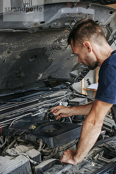 Auto mechanic repairing car in garage