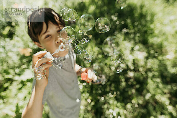 Boy playing with bubble wand at park