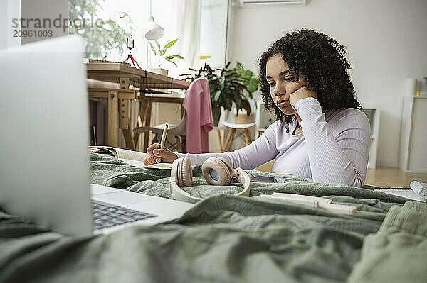 Curly haired girl doing homework at home