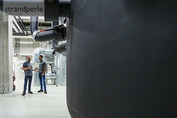 Two employees using laptop in factory