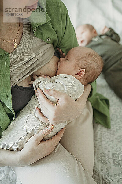 Mother breastfeeding son at home