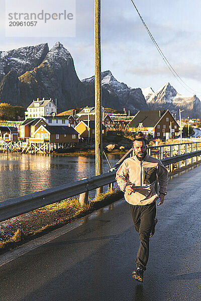 Man jogging on bridge near lake