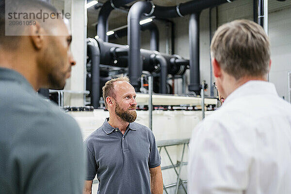 Businessman and employees having a meeting in factory