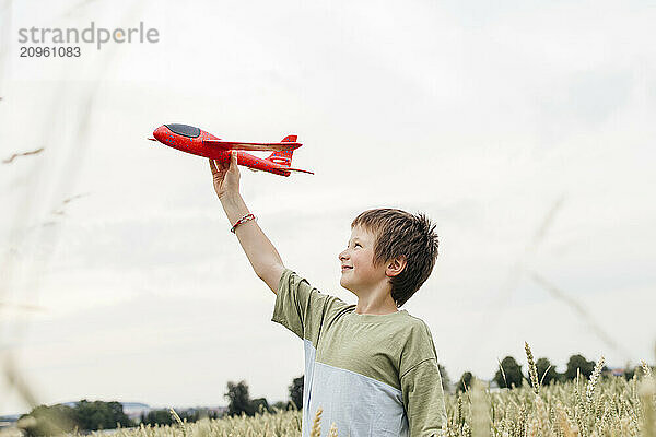 Boy playing with airplane on field