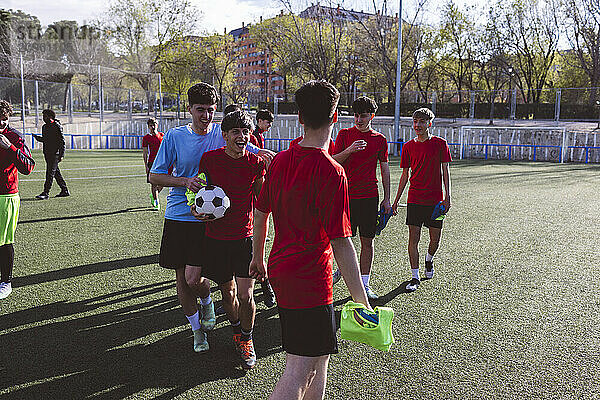 Happy soccer player walking with teammates on field