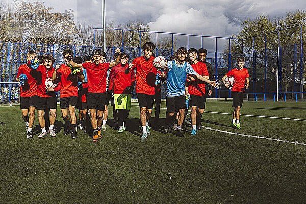 Cheerful soccer team winning match on sunny day