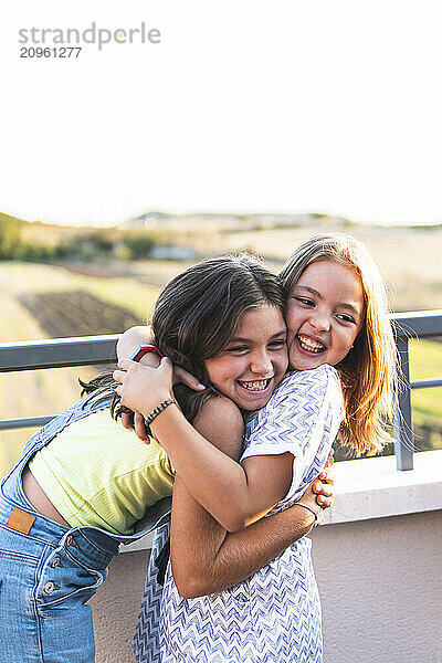 Friends embracing each other on rooftop of building