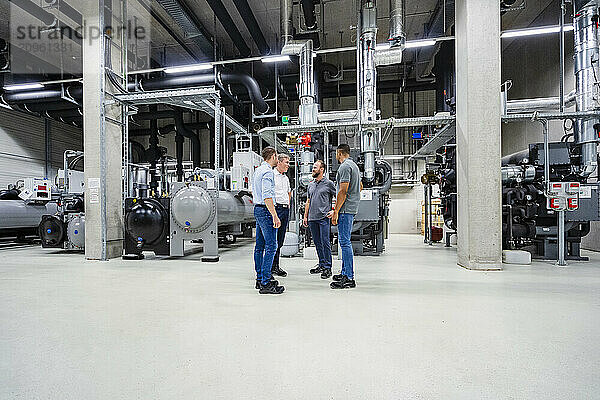 Businessmen and employees having a meeting in factory