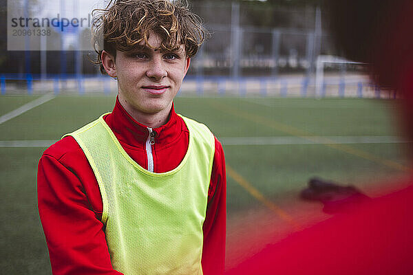 Smiling teenage soccer player on field