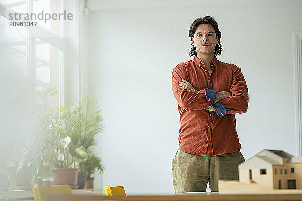 Architect standing with arms crossed at home