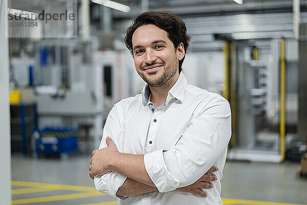 Confident young businessman at factory