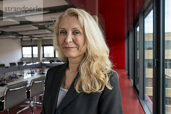 Smiling senior blond businesswoman at office