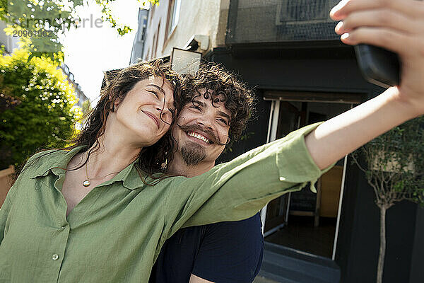 Happy couple taking selfie through smart phone