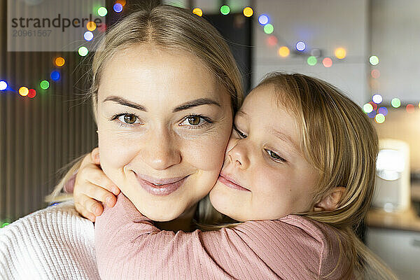 Daughter embracing mother in Christmas at home