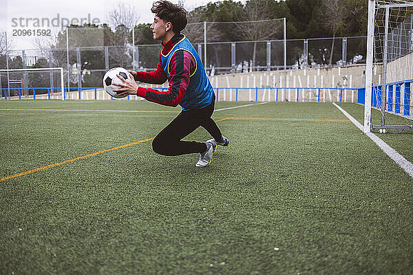 Goalie defending soccer ball on field