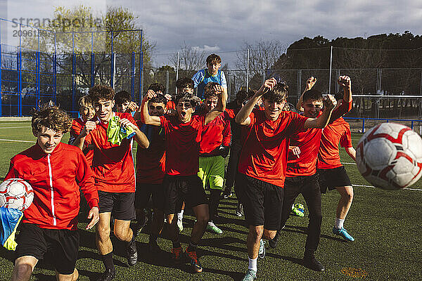 Happy soccer team winning match on sunny day