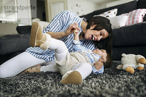 Mother playing with son lying down at home