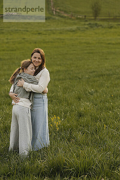 Daughter embracing mother at meadow