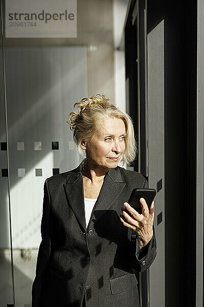 Businesswoman holding smart phone at office