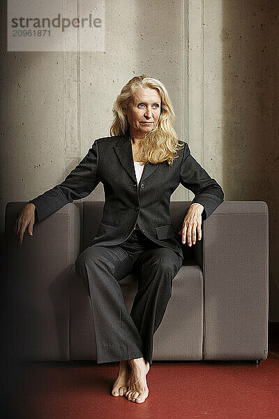 Blond businesswoman sitting on chair at office