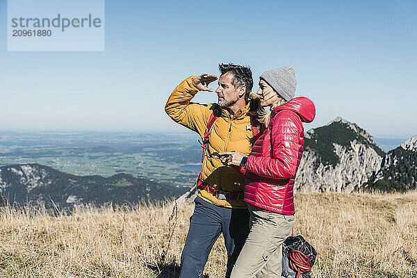 Friends looking at view standing on mountain