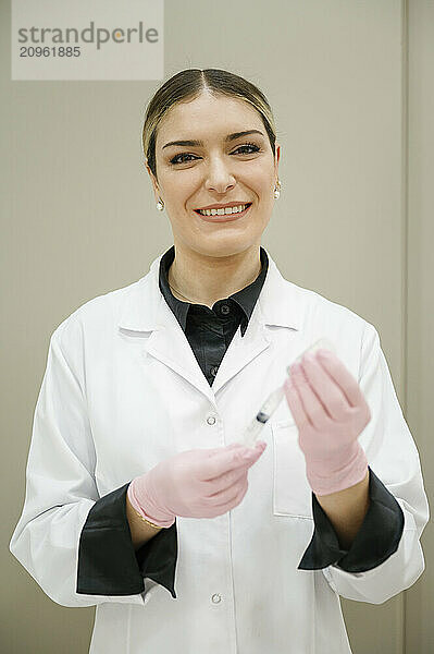 Dermatologist holding syringe in medical clinic