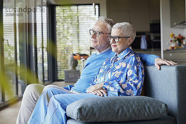 Senior couple sitting on couch at home