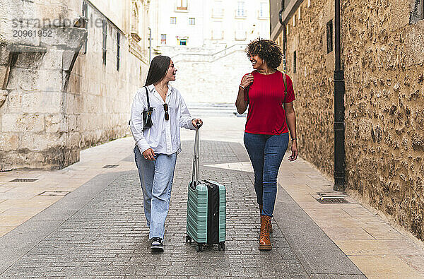 Happy tourist friends walking on street