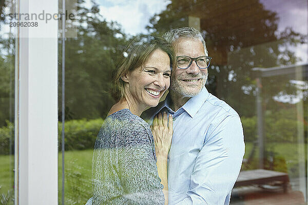 Affectionate couple standing near window