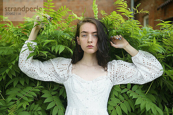 Girl in white dress standing at garden