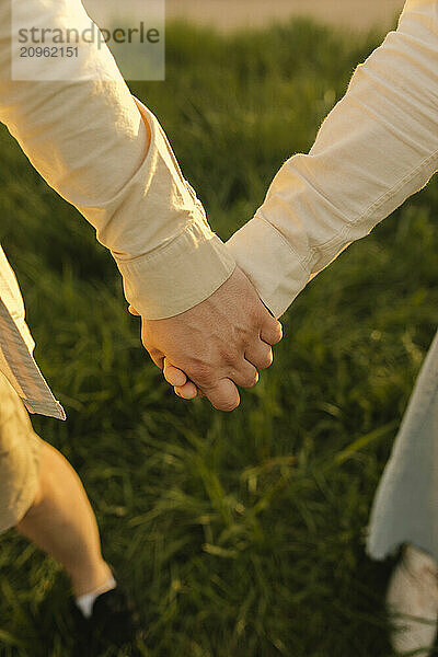 Man and woman holding hands at meadow