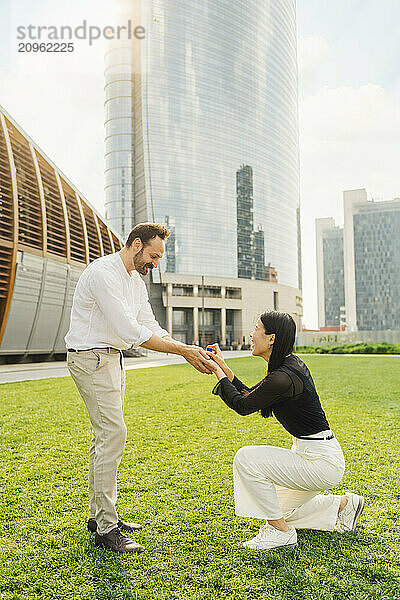 Happy woman proposing man on sunny day in park