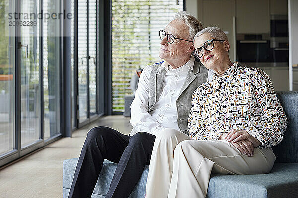 Senior couple sitting on couch at home