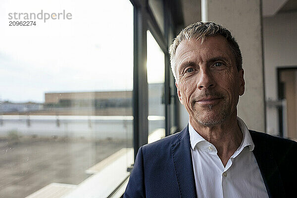 Senior businessman near glass window at office