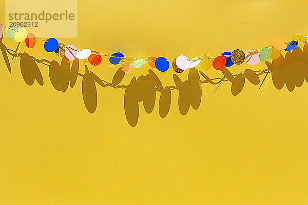 Colorful birthday garland against yellow background