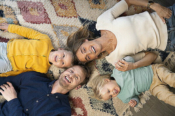 Happy family lying together on carpet at home