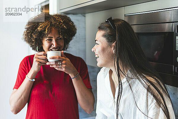 Cheerful woman having communication with roommate in hotel room