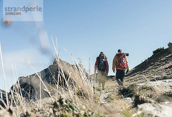 Friends with backpack walking on Tannheim Valley