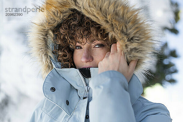 Curly hair woman in winter coat with fur hood