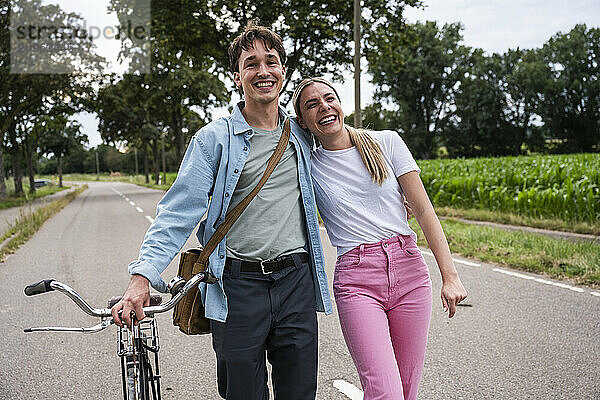 Smiling young man walking with girlfriend on road