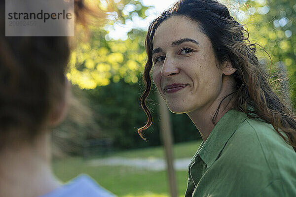 Smiling woman with long hair at park