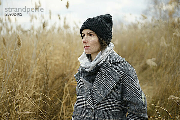 Woman wearing knit hat and standing in reeds