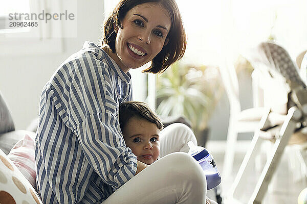 Smiling woman with son sitting at home