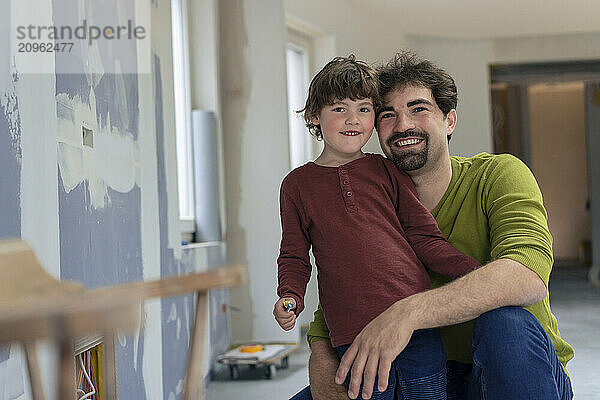 Smiling man with son at new apartment