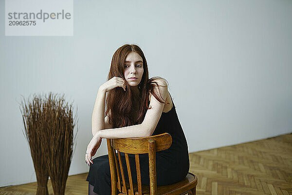 Beautiful woman sitting on chair at home