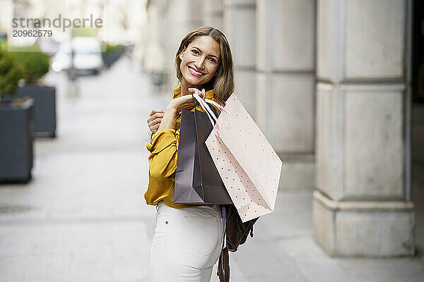 Happy woman with shopping bags at street