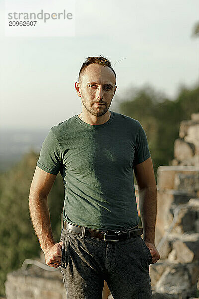 Confident man standing with hands in pockets