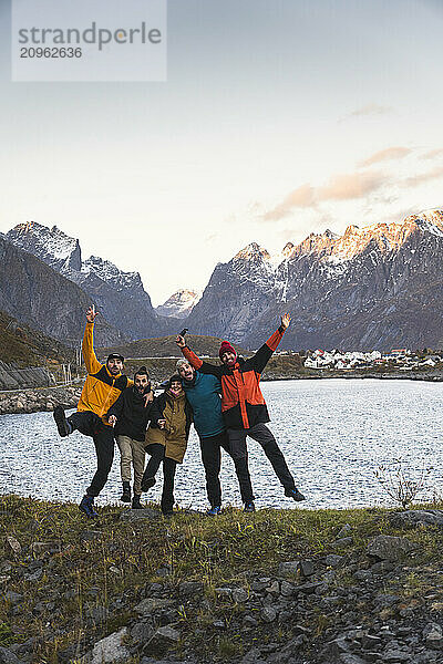 Cheerful friends enjoying leisure time near lake