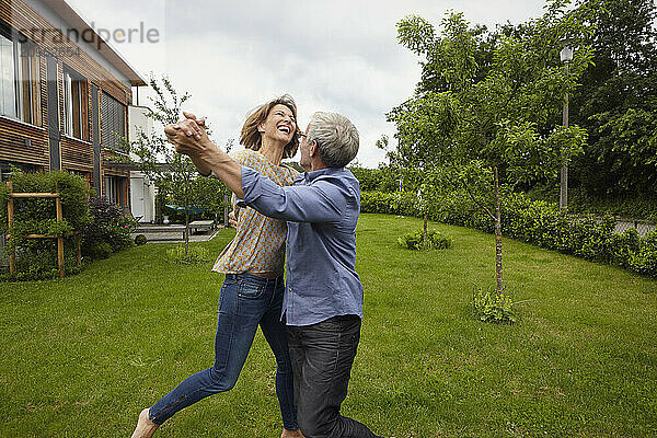 Mature couple dancing in back yard