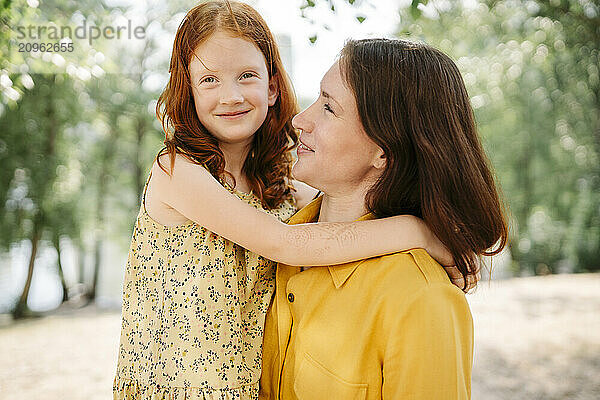 Smiling mother looking at daughter in park